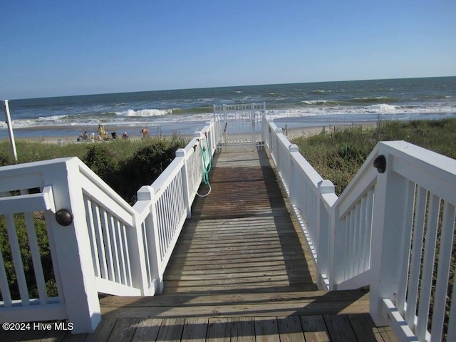 view of home's community featuring a water view and a beach view