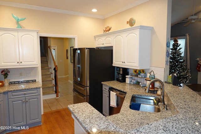 kitchen with white cabinets, stainless steel appliances, and light stone counters