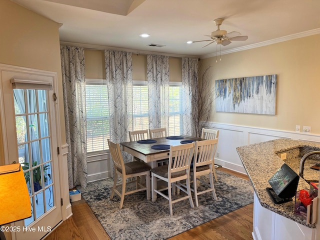 dining space featuring ceiling fan, crown molding, and dark wood-type flooring