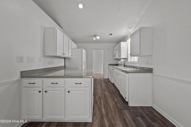 kitchen featuring dark hardwood / wood-style flooring, white appliances, a textured ceiling, sink, and white cabinets