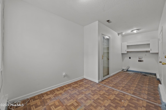 laundry room with dark parquet flooring and a textured ceiling