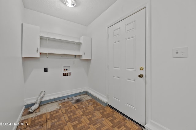 washroom featuring electric dryer hookup, cabinets, dark parquet floors, hookup for a washing machine, and a textured ceiling