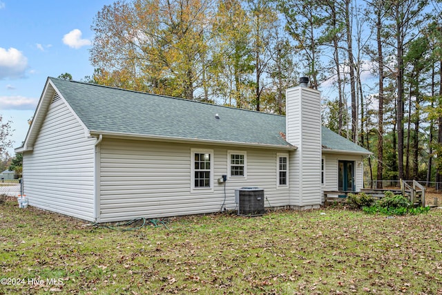 back of house featuring a yard and central AC