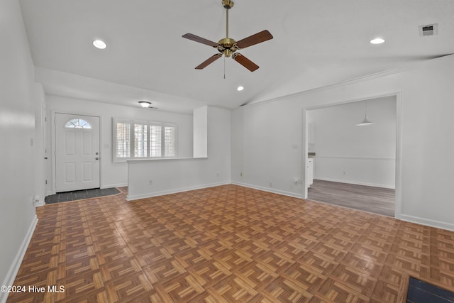 interior space with ceiling fan, dark parquet floors, and vaulted ceiling