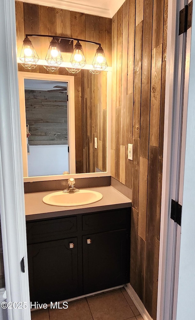 bathroom featuring tile patterned flooring, vanity, and wooden walls