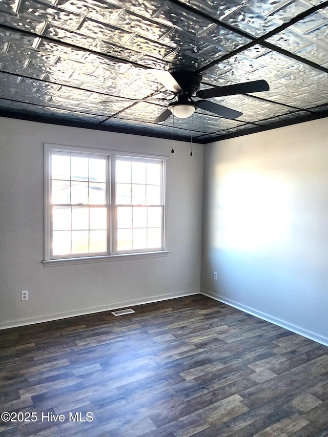 unfurnished room with ceiling fan and dark hardwood / wood-style flooring