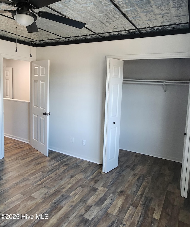 unfurnished bedroom featuring ceiling fan, dark hardwood / wood-style floors, and a closet