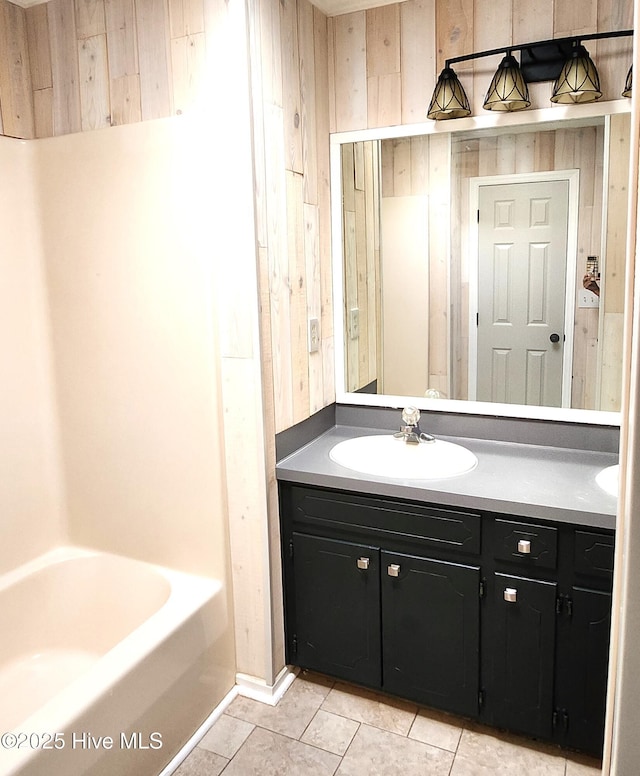 bathroom with tile patterned floors, vanity, and wooden walls