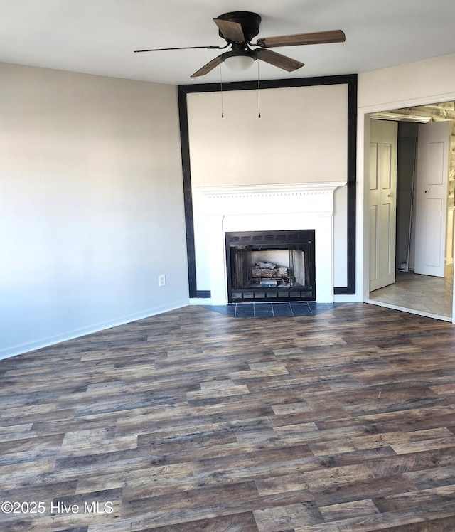 unfurnished living room with ceiling fan and dark wood-type flooring