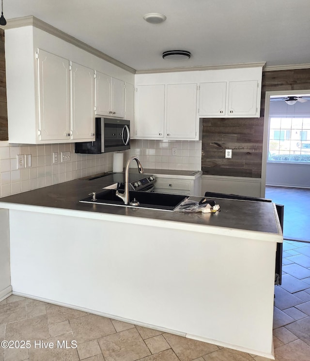 kitchen with kitchen peninsula, white cabinetry, and sink