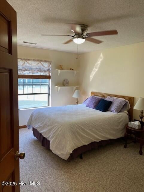 202 Country Club Villa Dr # 2, Shallotte, NC 28470 - bedroom with carpet floors, a textured ceiling, and a ceiling fan