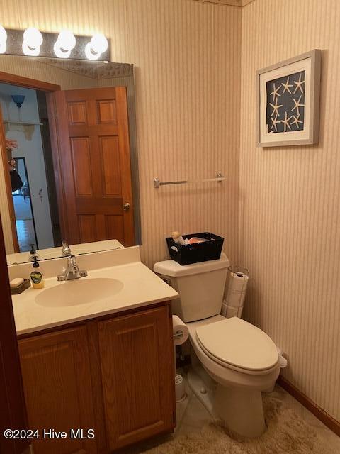 bathroom with tile patterned flooring, vanity, and toilet