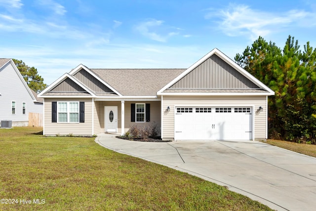 view of front of home featuring a garage, central air condition unit, and a front yard