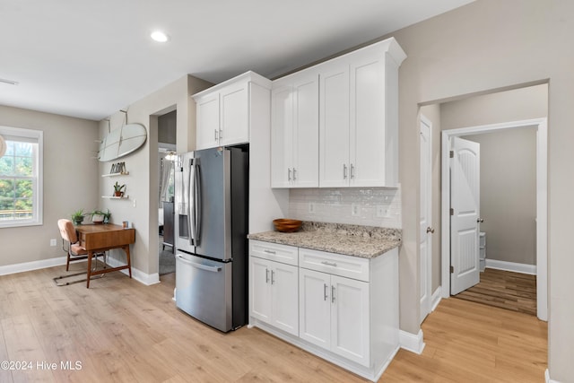 kitchen with backsplash, stainless steel fridge with ice dispenser, light hardwood / wood-style flooring, and white cabinets