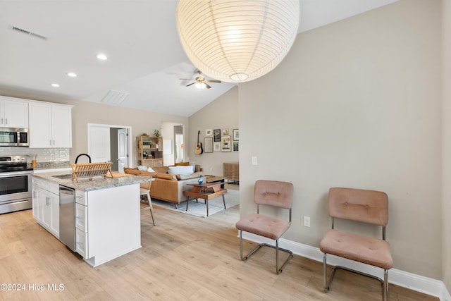 kitchen with sink, white cabinets, light hardwood / wood-style floors, and appliances with stainless steel finishes