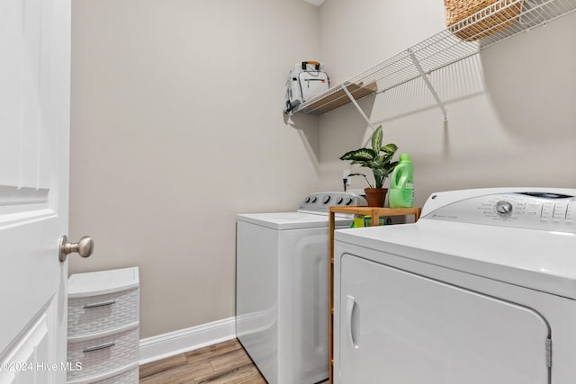 washroom with independent washer and dryer and light hardwood / wood-style flooring