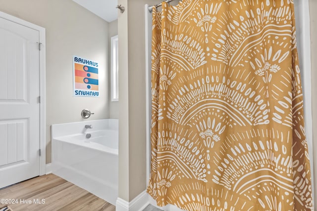 bathroom featuring hardwood / wood-style floors and a bath