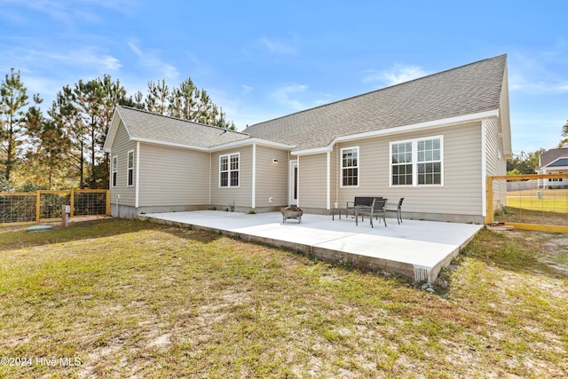 rear view of house with a lawn and a patio