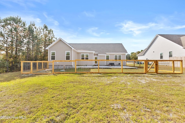 rear view of property with a lawn