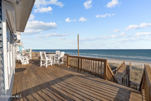 wooden deck with a water view and a view of the beach