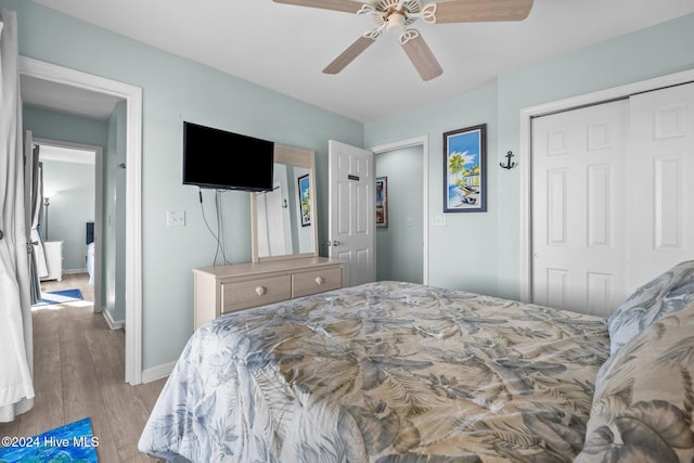 bedroom with ceiling fan, a closet, and light hardwood / wood-style flooring