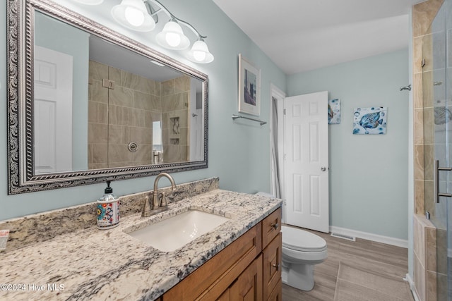 bathroom with vanity, toilet, wood-type flooring, and a shower with door