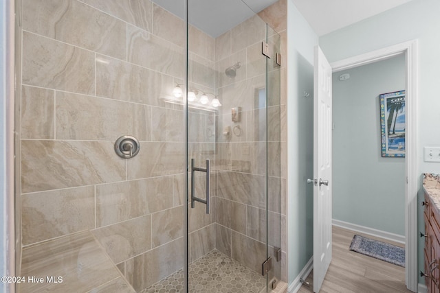 bathroom featuring vanity, an enclosed shower, and hardwood / wood-style flooring