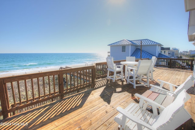 deck featuring a beach view and a water view