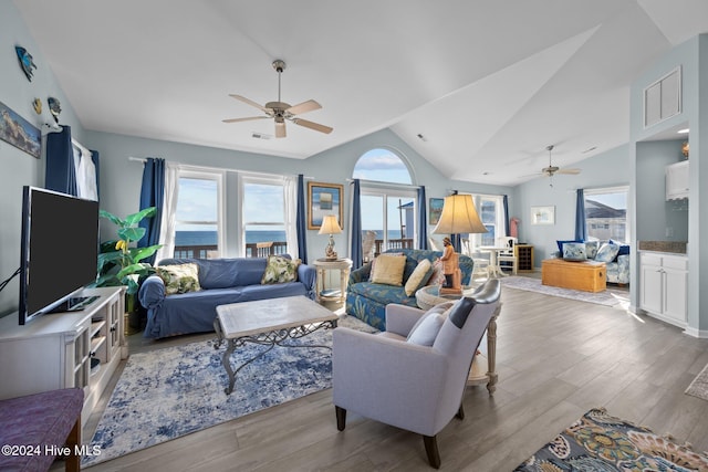 living room featuring ceiling fan, light wood-type flooring, and lofted ceiling