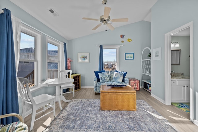 living area featuring a wealth of natural light, ceiling fan, lofted ceiling, and hardwood / wood-style flooring