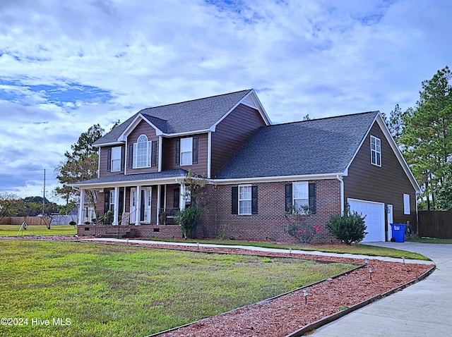 view of property featuring a porch, a garage, and a front lawn