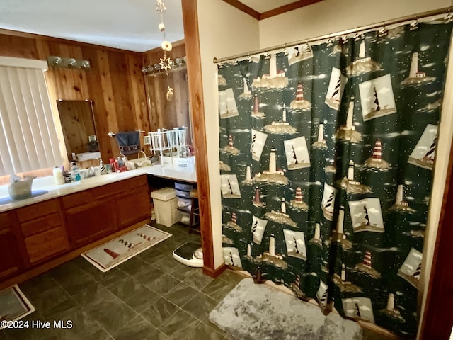 bathroom featuring wooden walls, crown molding, vanity, and a chandelier