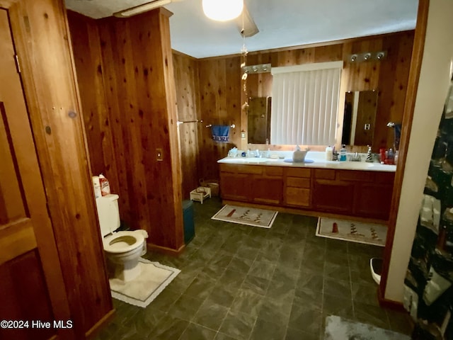 bathroom featuring vanity, ceiling fan, and wood walls