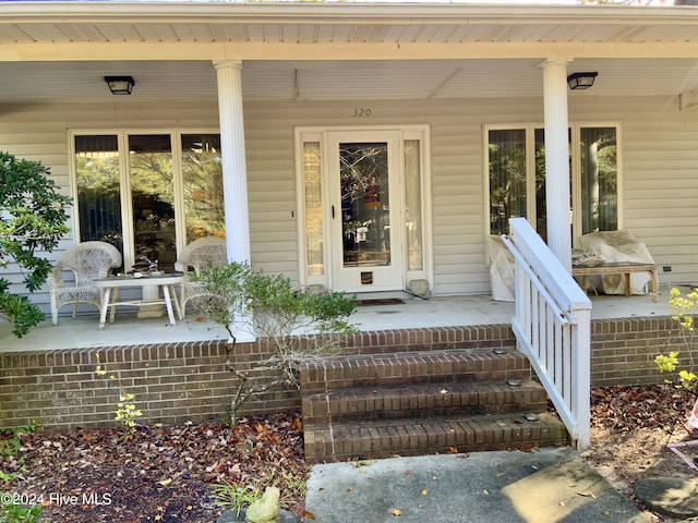 view of exterior entry featuring covered porch