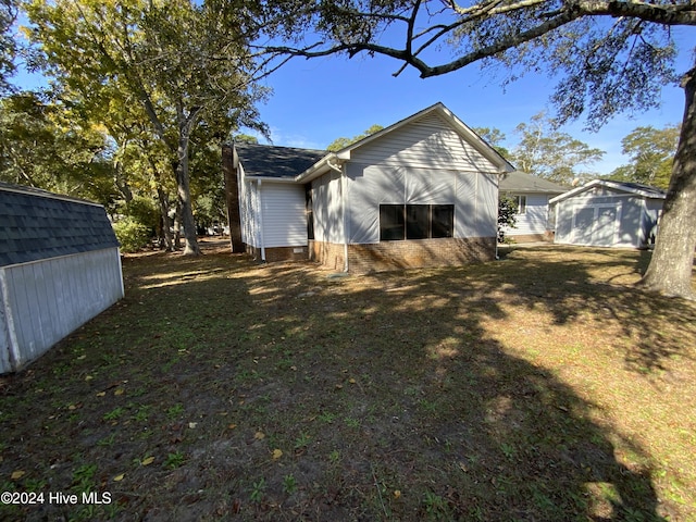 back of house with an outbuilding and a yard