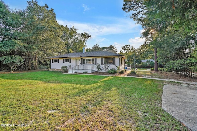 single story home featuring covered porch and a front lawn