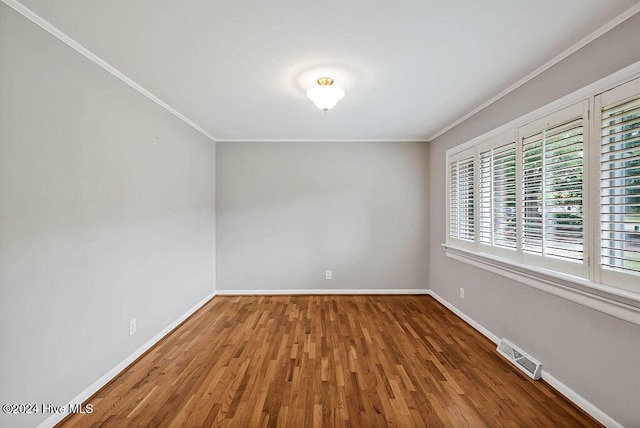 spare room with crown molding and hardwood / wood-style floors