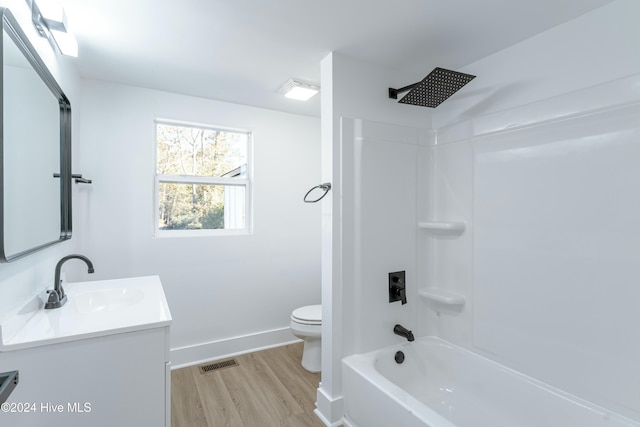 full bathroom with hardwood / wood-style floors, vanity, shower / bathtub combination, and toilet