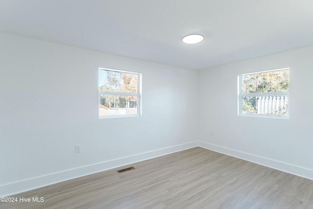 unfurnished room with light wood-type flooring and plenty of natural light