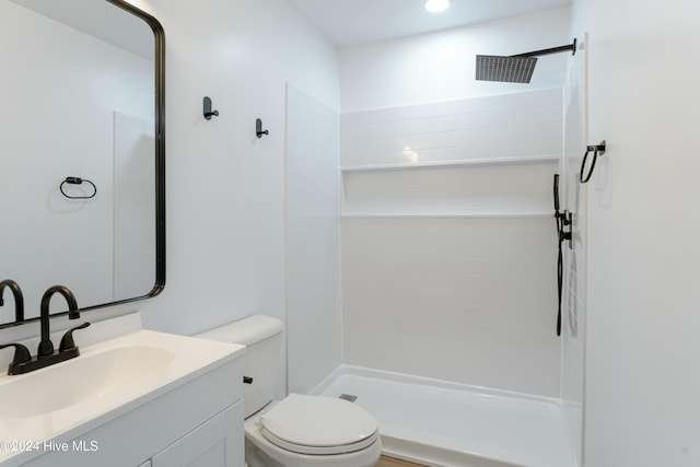 bathroom with a shower, vanity, and toilet