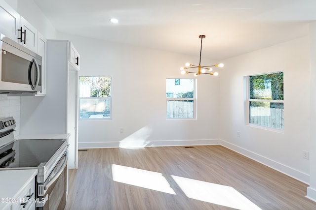 kitchen featuring backsplash, stainless steel appliances, light hardwood / wood-style flooring, an inviting chandelier, and white cabinets