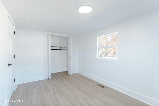 unfurnished bedroom with light hardwood / wood-style floors and a closet