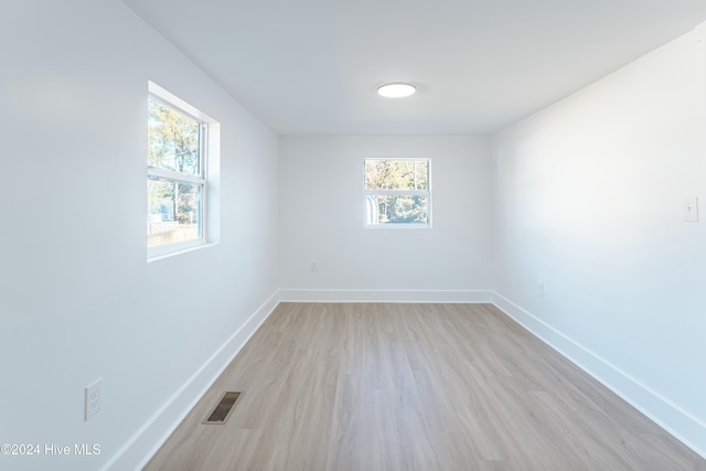 empty room with a healthy amount of sunlight and light hardwood / wood-style floors