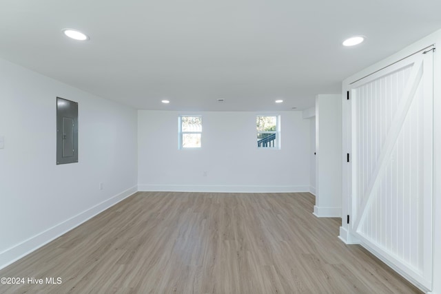 interior space with electric panel and light hardwood / wood-style flooring