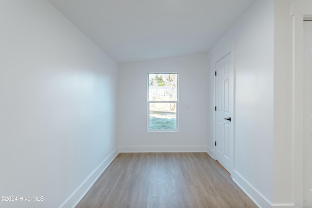 empty room featuring light hardwood / wood-style floors and vaulted ceiling