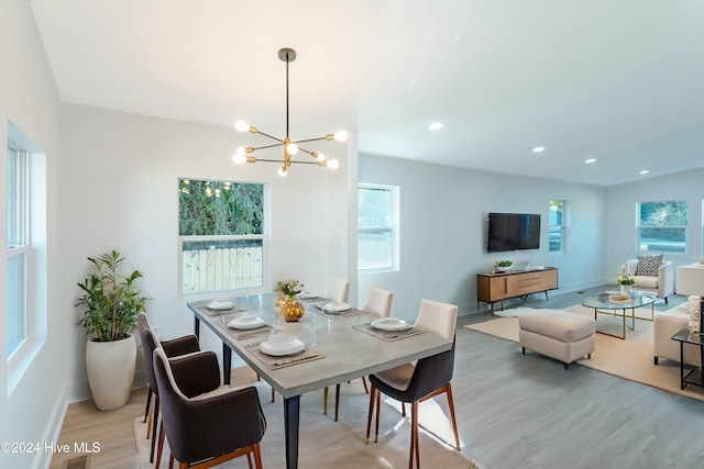 dining space with a chandelier and light wood-type flooring