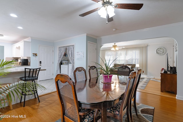 dining space with crown molding, light hardwood / wood-style floors, and ceiling fan with notable chandelier