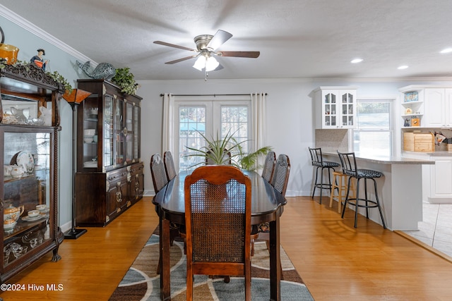 dining space featuring french doors, a textured ceiling, ceiling fan, crown molding, and light hardwood / wood-style flooring