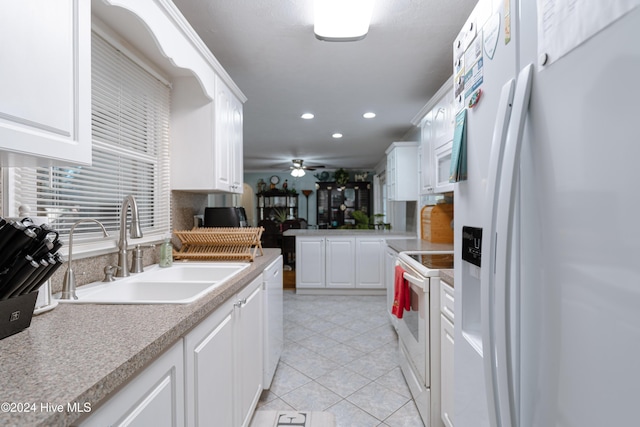 kitchen with white appliances, sink, ceiling fan, light tile patterned floors, and white cabinetry