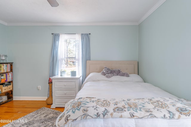 bedroom featuring ceiling fan, light wood-type flooring, and crown molding